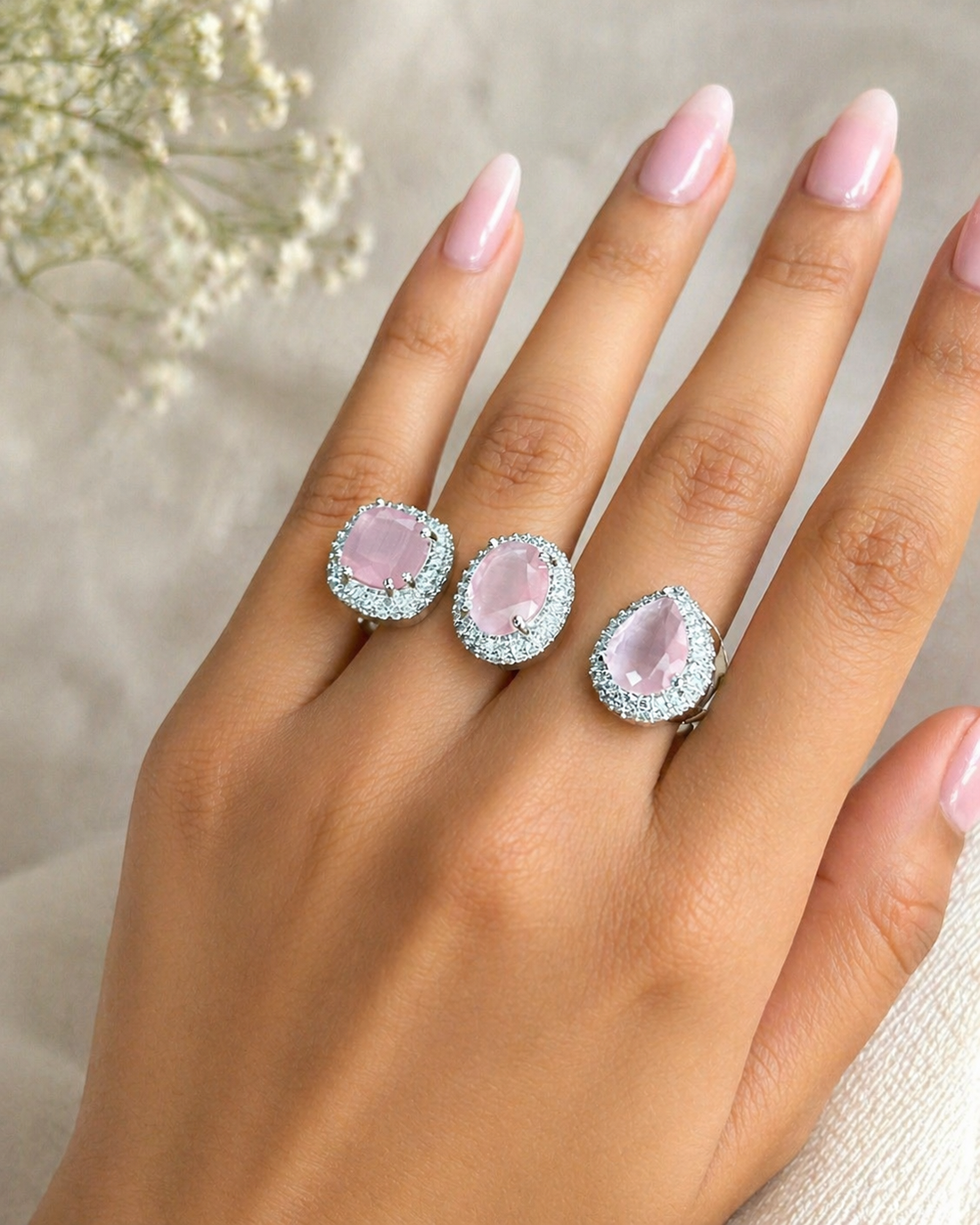 Silver ring with baby pink gemstones on a white surface with gypsy 

