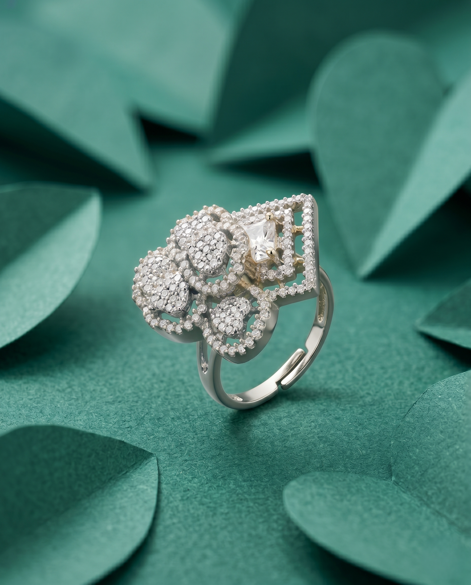 Silver ring with floral design on a green leafy background