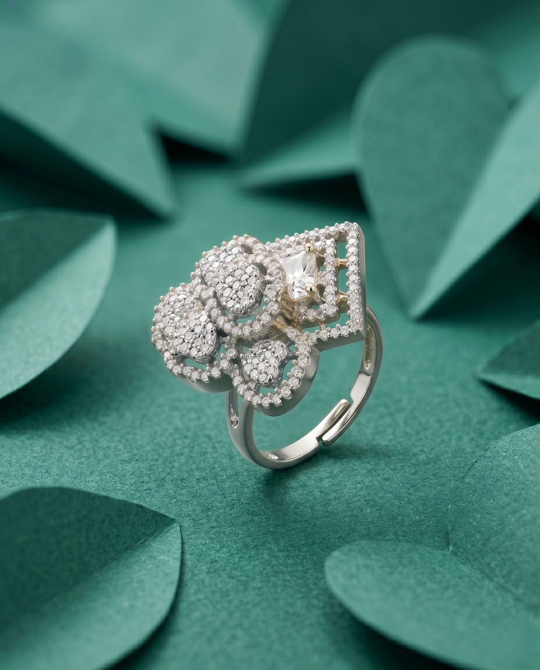 Silver ring with floral design on a green leafy background