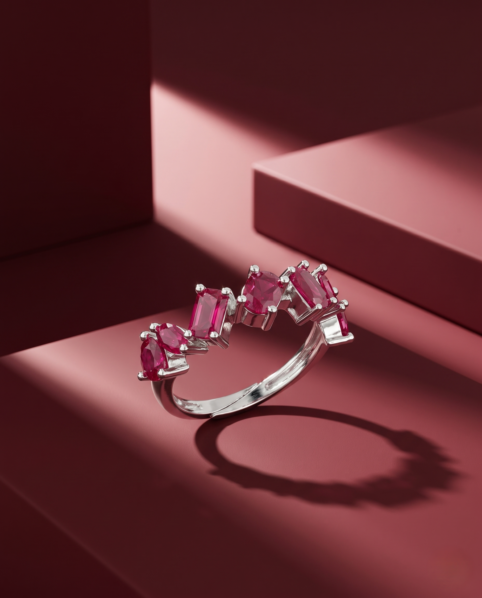 Silver ring with pink gemstones on a red background