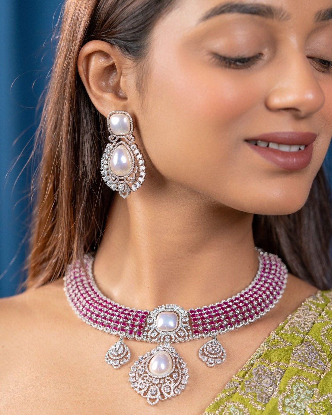 Woman wearing a silver and pink jewelry set with a blurred background