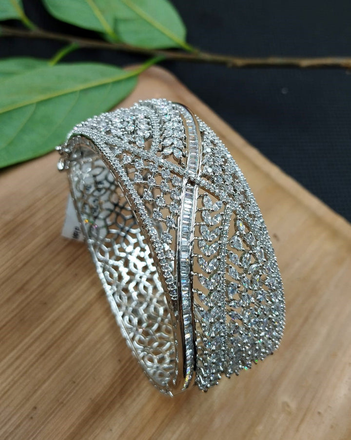 Silver bracelet with intricate design on a wooden surface