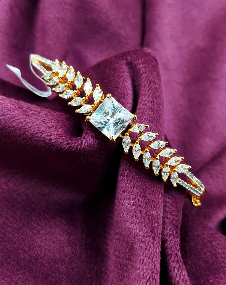 Gold and diamond earring on a purple fabric background