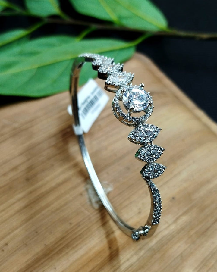 Silver bracelet with diamond accents on a wooden surface