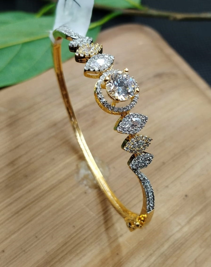 Gold bracelet with diamond accents on a wooden surface