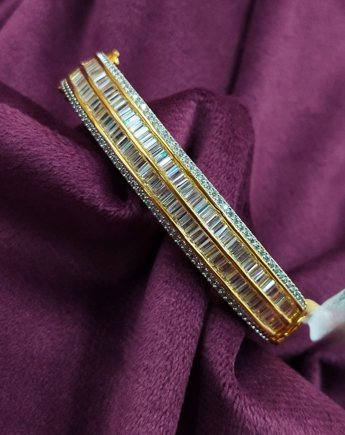 Gold and diamond bracelet on a purple fabric background