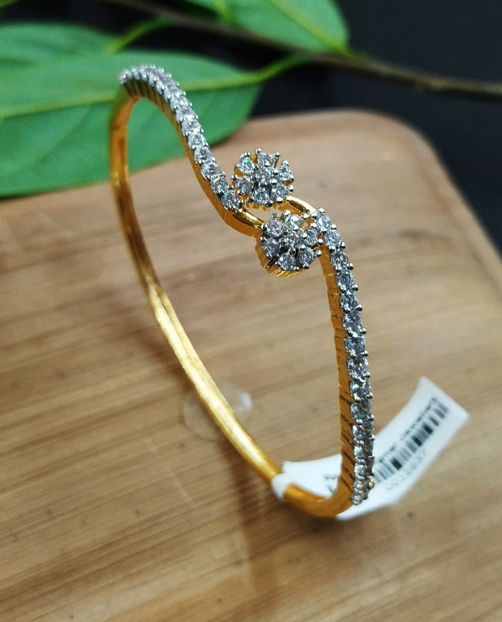 Gold bracelet with diamond accents on a wooden surface
