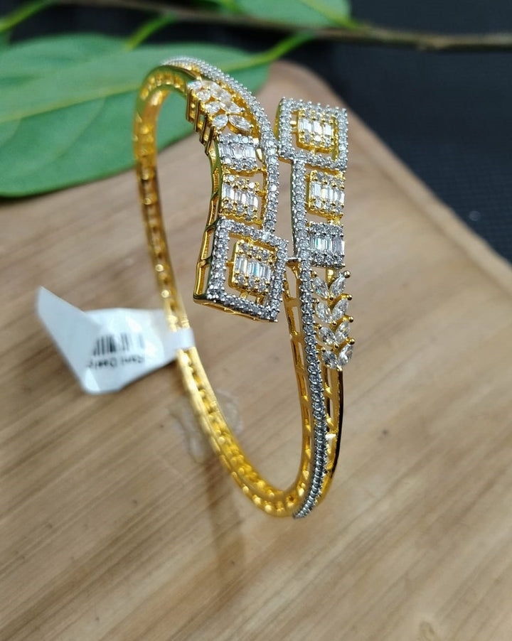 Gold bracelet with diamond accents on a wooden surface