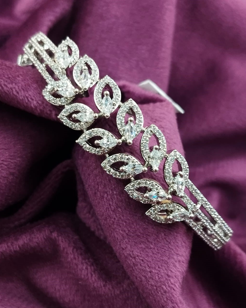Silver bracelet with clear stones on a purple fabric background