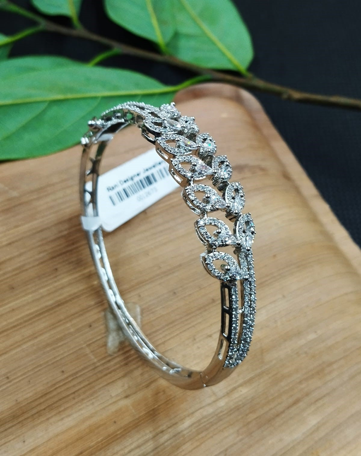Silver bracelet with intricate design on a wooden surface