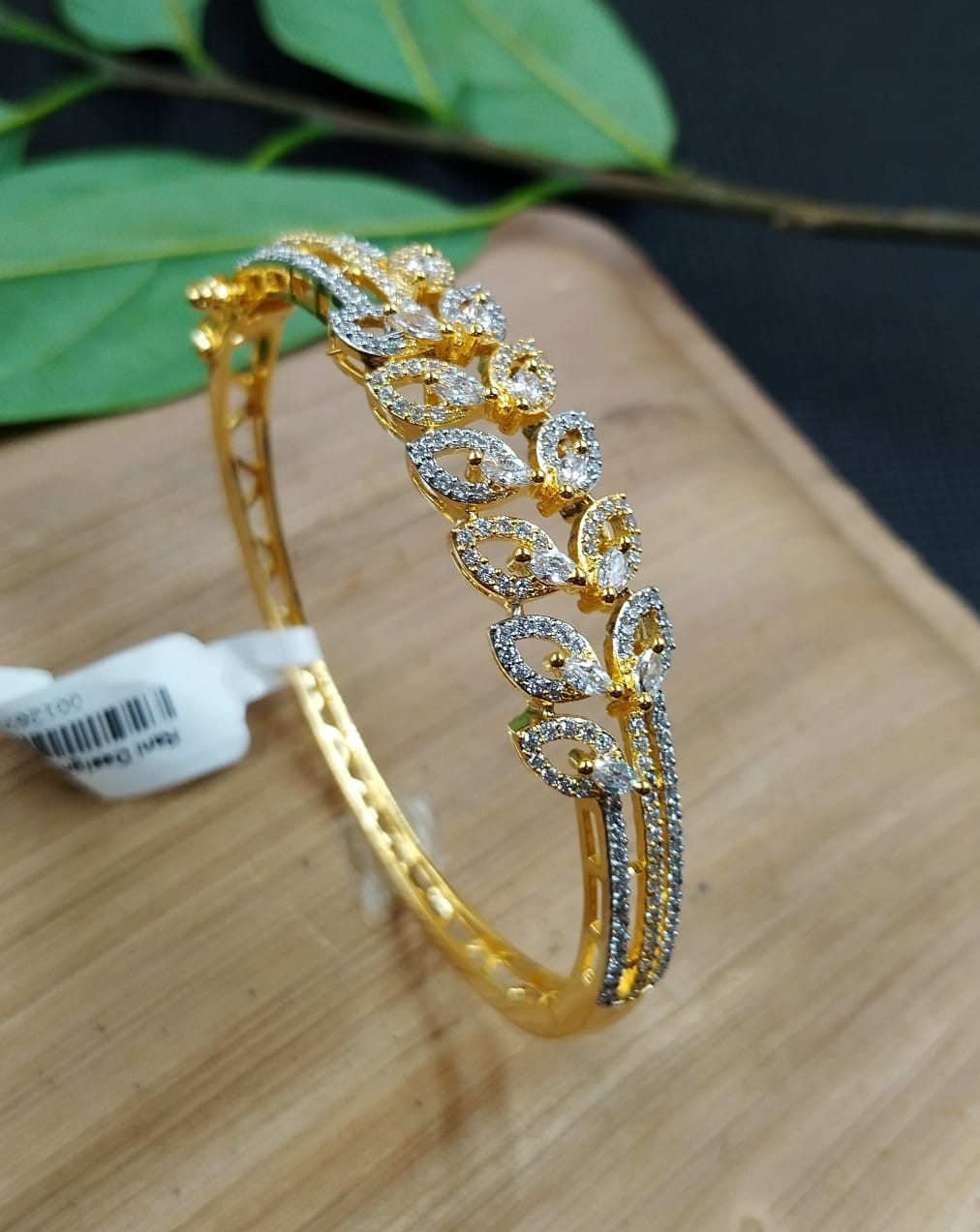 Gold bracelet with diamond accents on a wooden surface