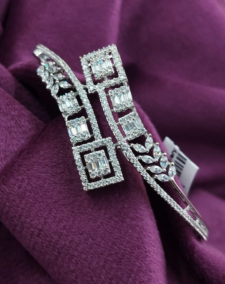 Silver brooch with gemstones on a purple fabric background