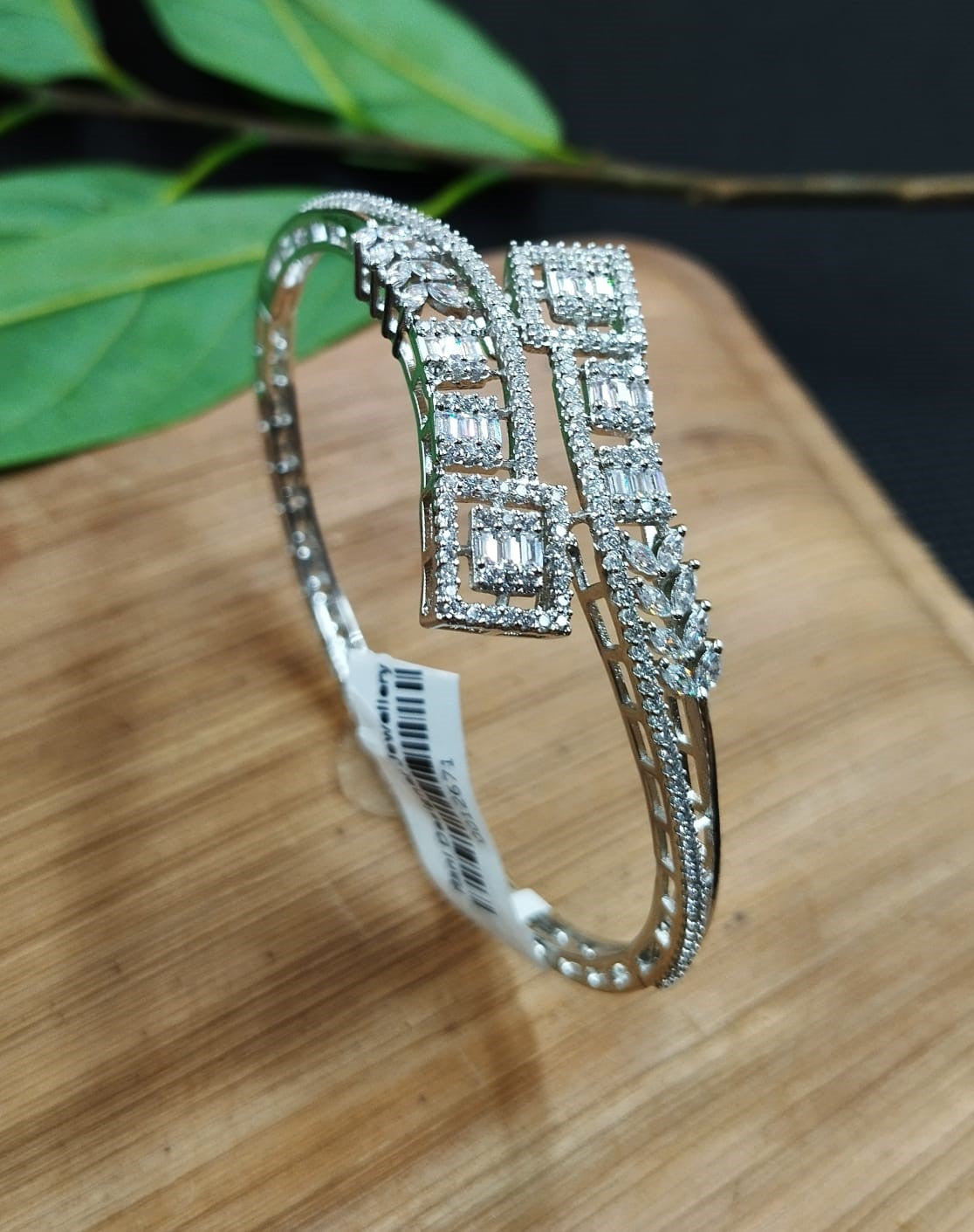 Silver bracelet with diamond accents on a wooden surface