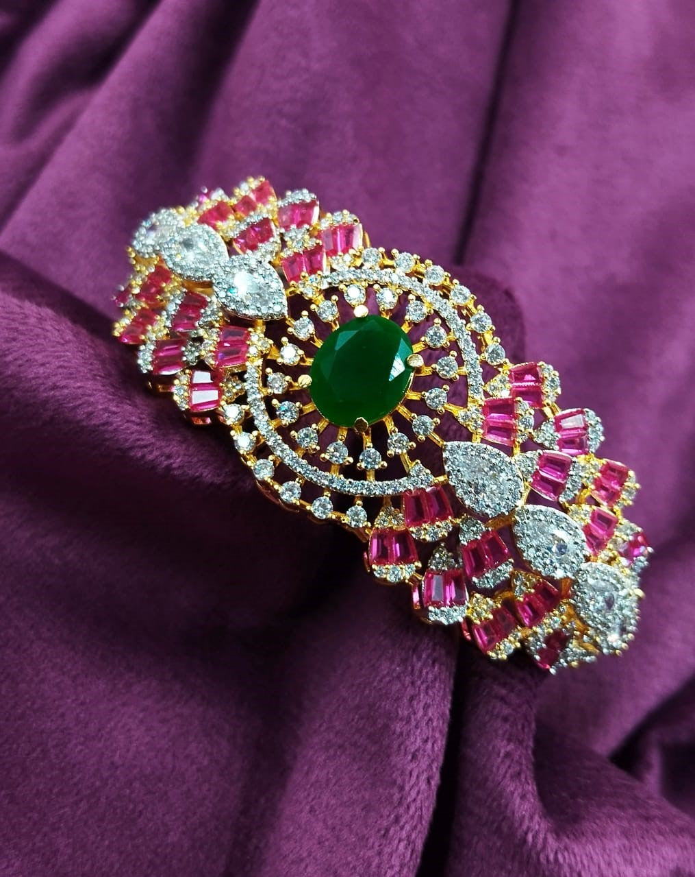 Decorative brooch with gemstones on a purple fabric background
