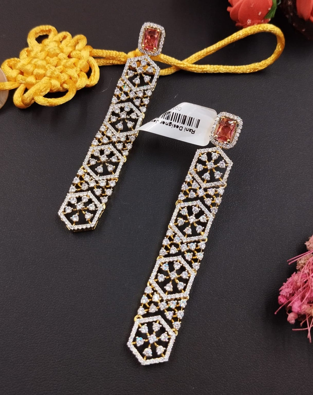 Decorative earrings with geometric patterns on a dark surface