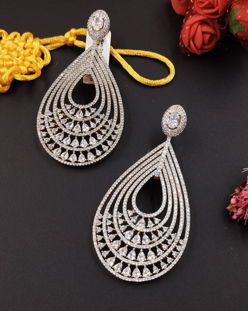 Ornate silver earrings on a dark surface with decorative elements.