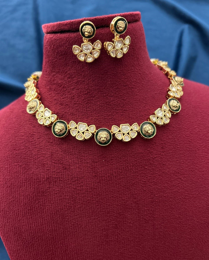 Gold necklace and earrings on a red velvet stand with a blue fabric background