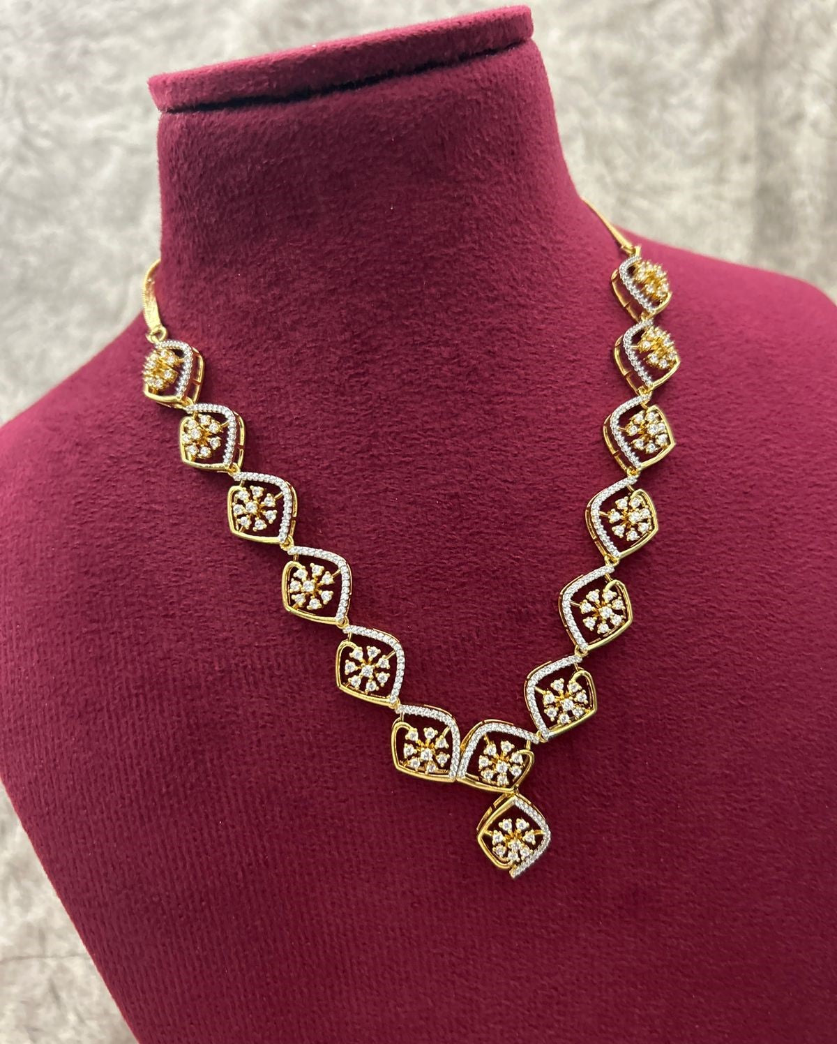 Gold necklace with diamond-like stones on a manneq