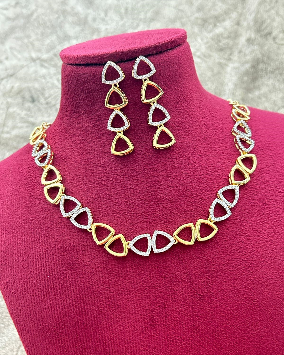 Jewelry set with necklace and earrings on a pink mannequin bust.