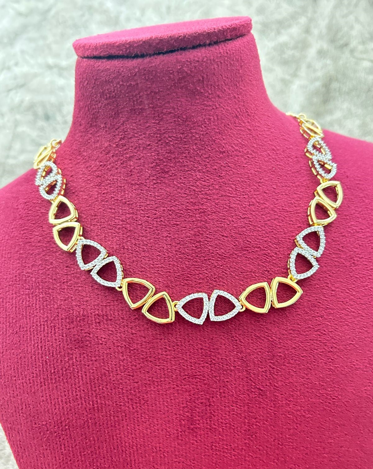 Necklace with gold and silver links on a pink mannequin