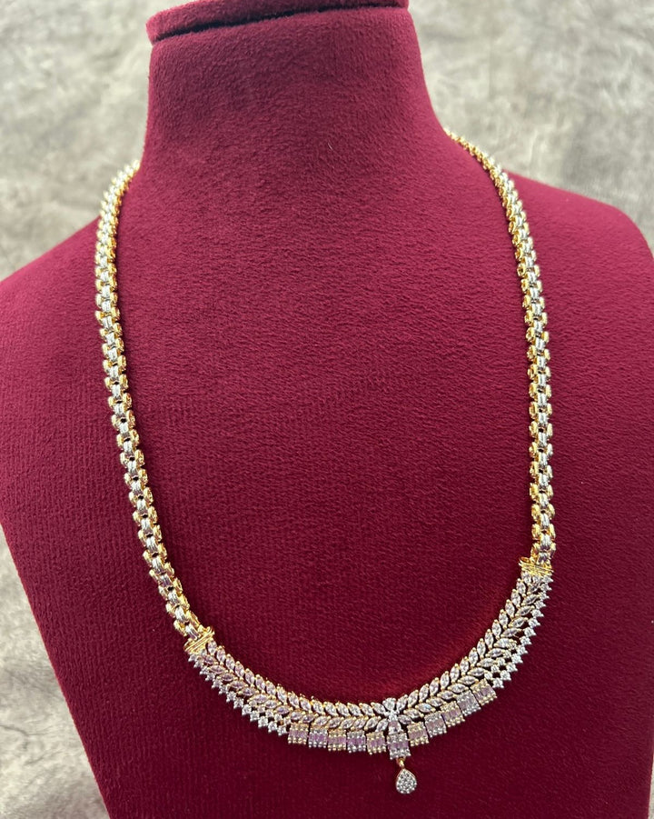 Gold and diamond necklace on a mannequin bust with a gray background