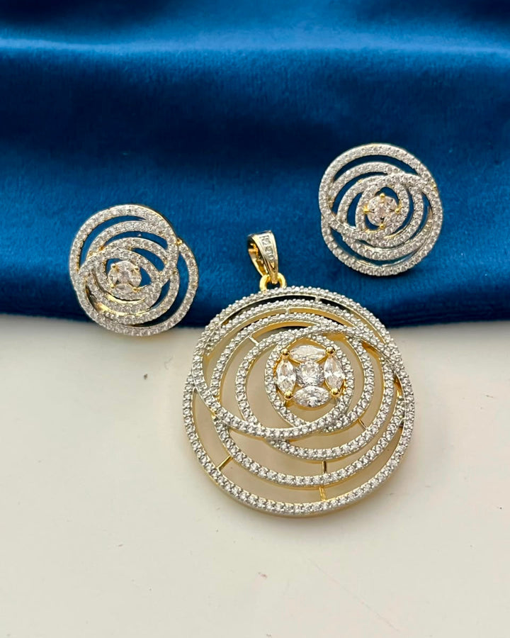 Gold and silver spiral pendant necklace set with matching stud earrings, displayed on a blue satin fabric background.