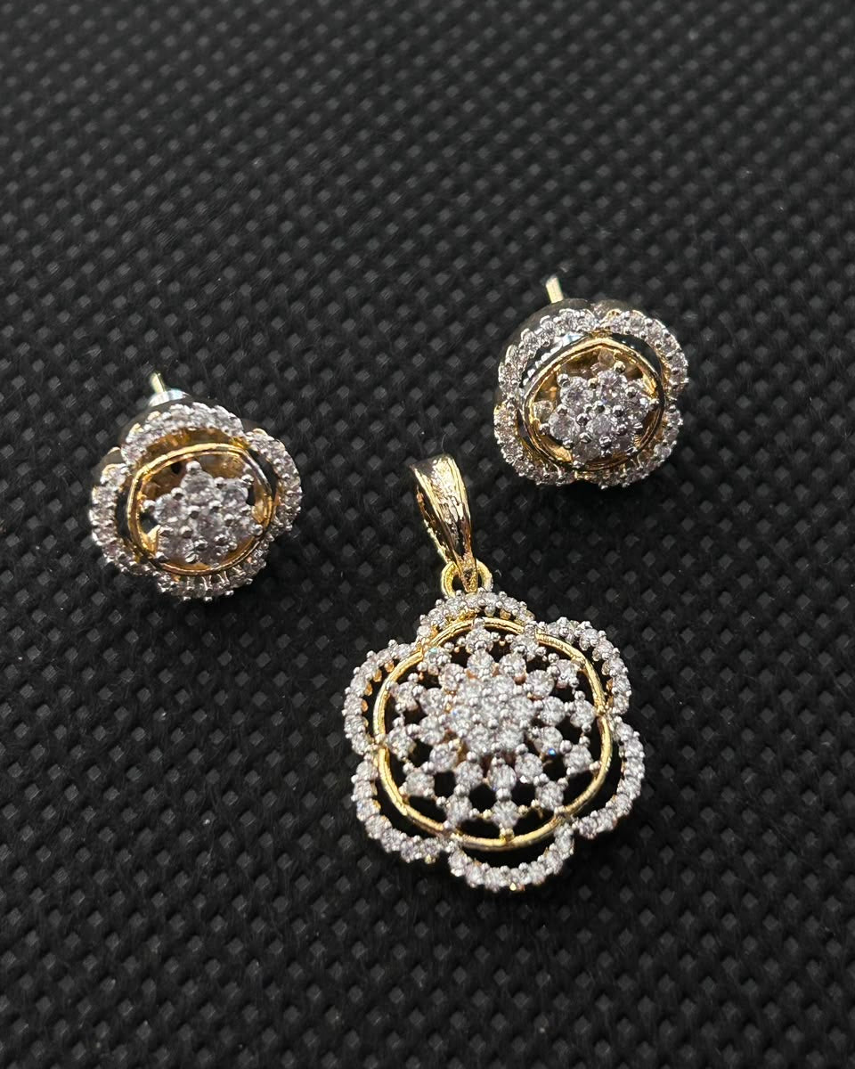 Gold and diamond jewelry set featuring a floral pendant and matching stud earrings, displayed on a textured black background.