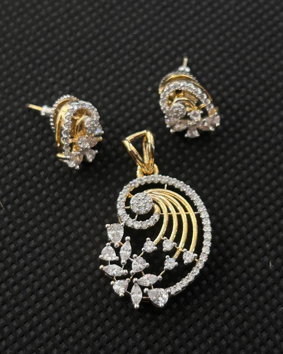 Gold and silver-tone jewelry set featuring a seashell-shaped pendant and matching stud earrings, embellished with clear stones, displayed on a textured black background.