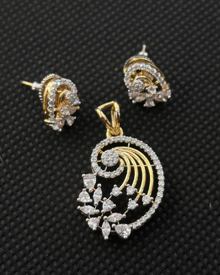 Gold and silver-tone jewelry set featuring a seashell-shaped pendant and matching stud earrings, embellished with clear stones, displayed on a textured black background.