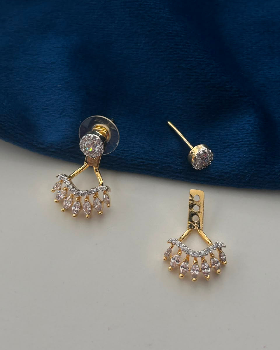Gold and crystal drop earrings displayed on a split white and dark blue velvet background.