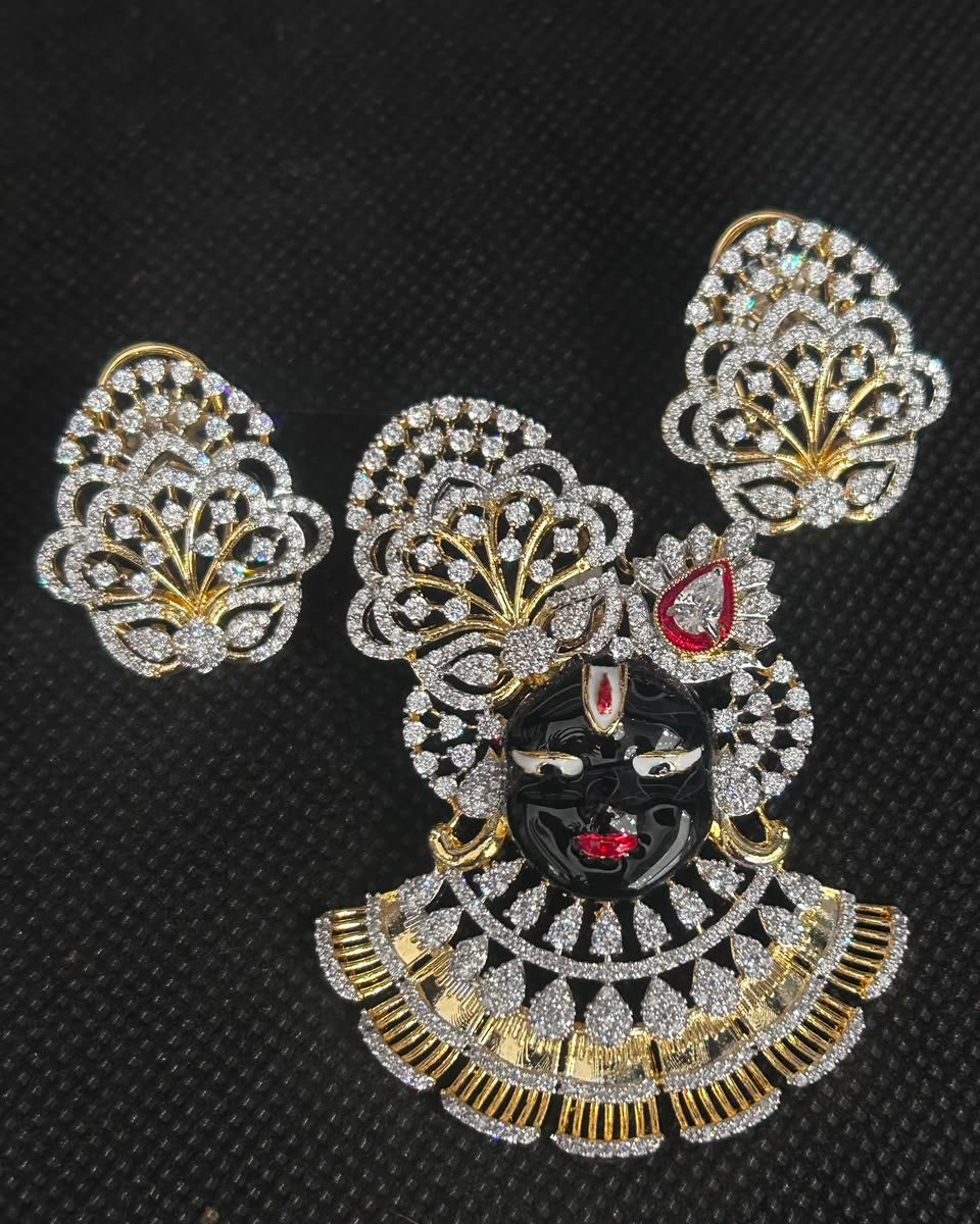 Gold and silver-tone jewelry set featuring a central decorative piece with a black face motif, red accents, and multiple matching fan-shaped leaf clusters, displayed on a black textured background.