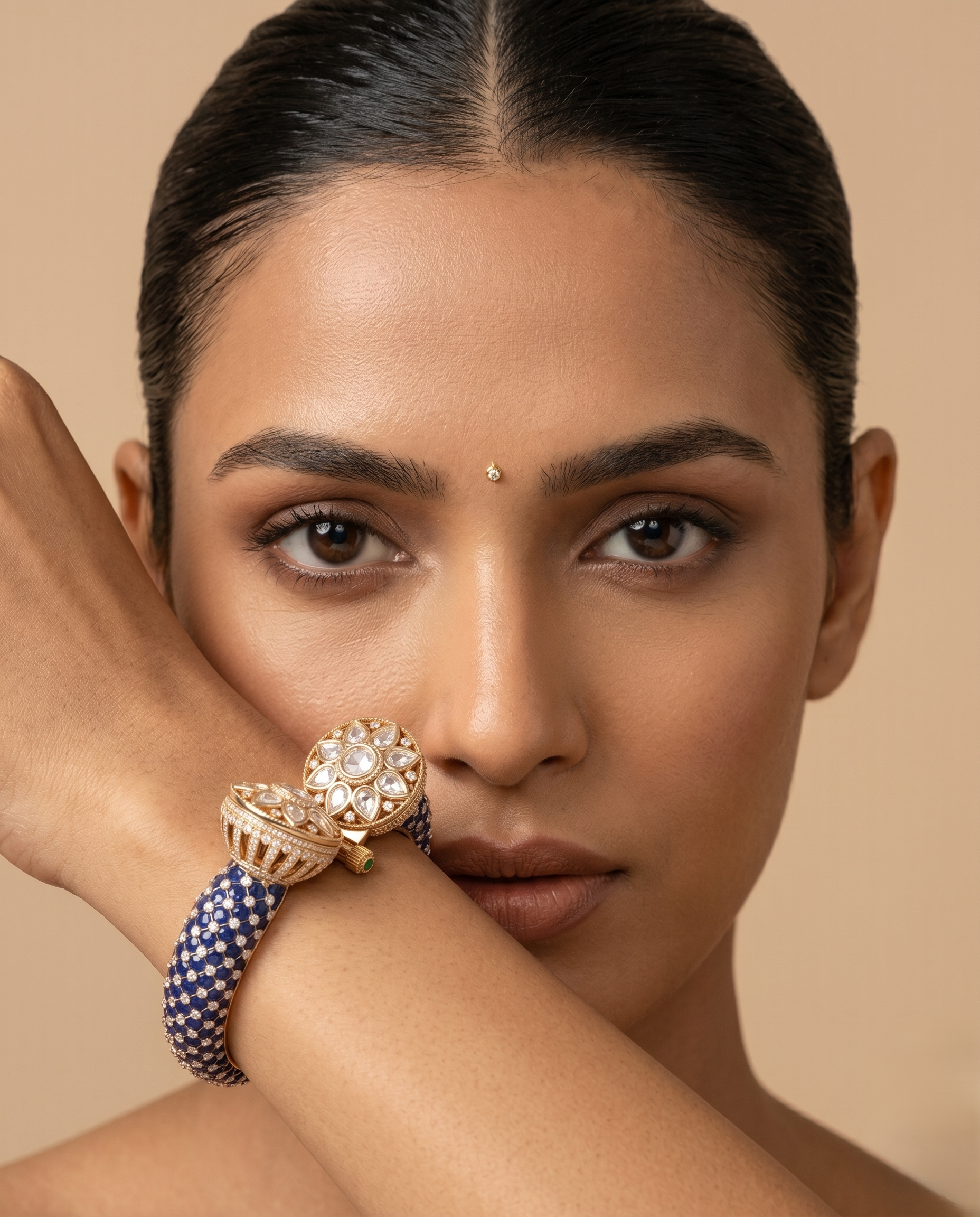 Woman wearing a gold and blue bracelet on a beige background