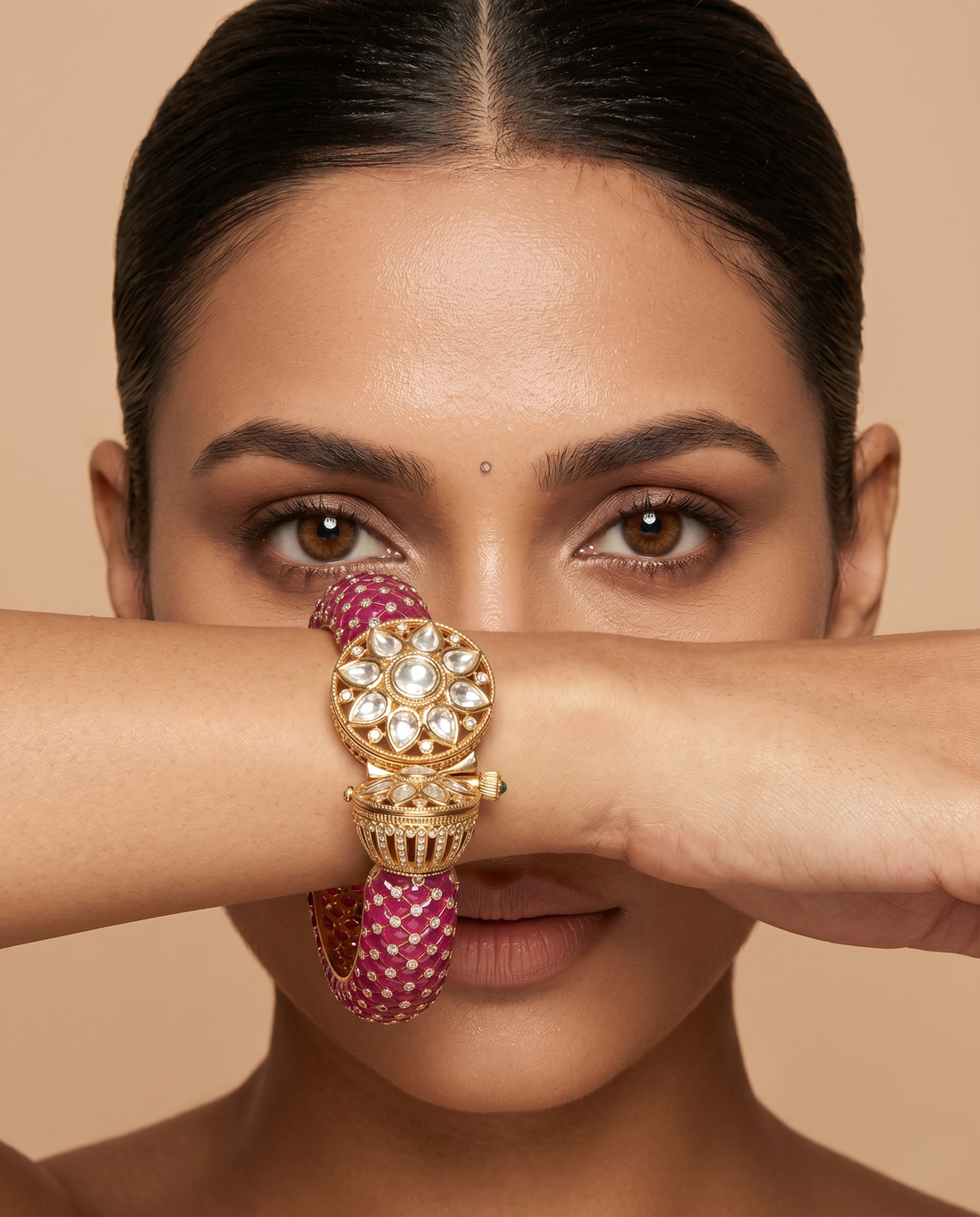 Woman wearing a gold and pink bracelet on a beige background
