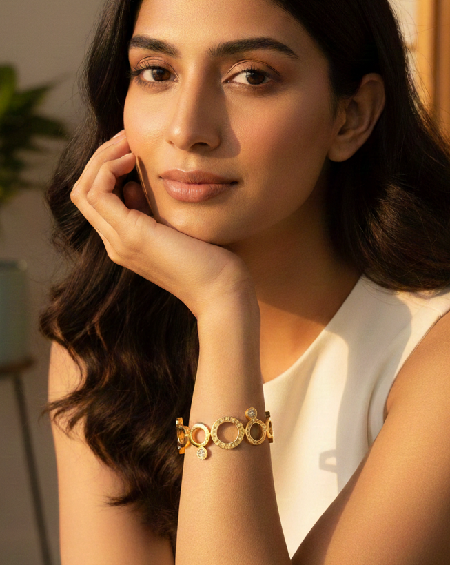Woman wearing a gold bracelet with a blurred background