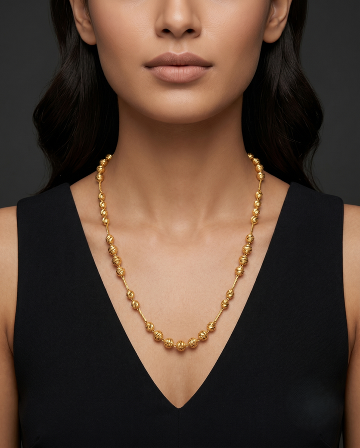 Woman wearing a gold necklace a dark background