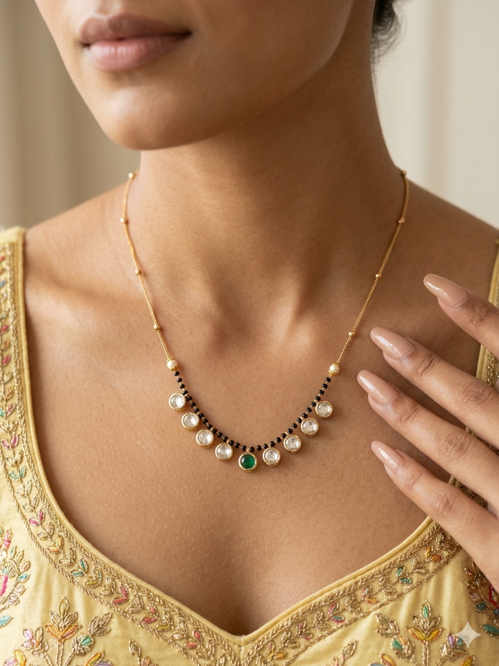 Woman wearing a gold necklace with pearls and emeralds, close-up of the necklace.
