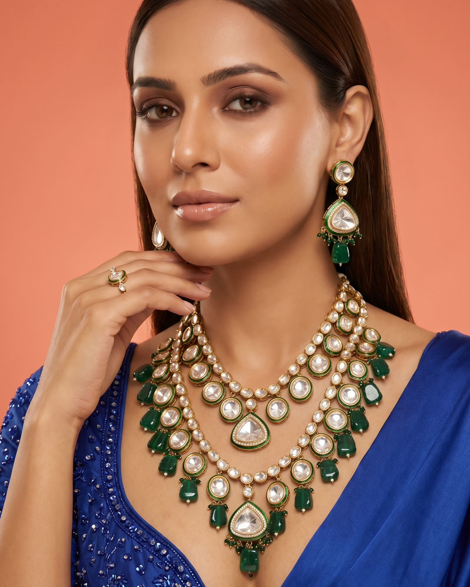 Woman wearing a luxurious green and gold necklace with a blue background