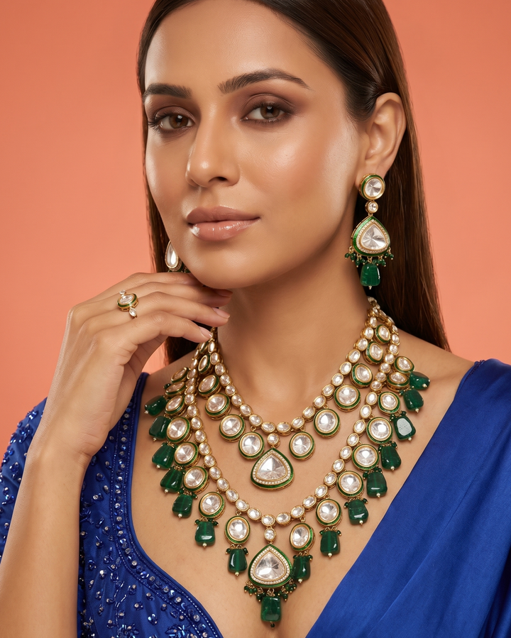Woman wearing a luxurious green and gold necklace with a blue background