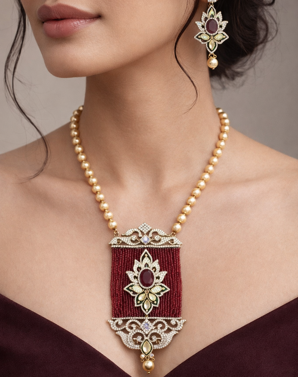 a red pendant and gold necklace with matching earrings 