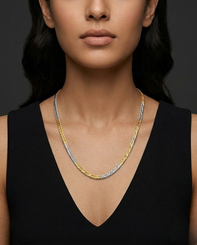 Woman wearing a three-strand necklace with gold, silver, and bronze links against a dark background
