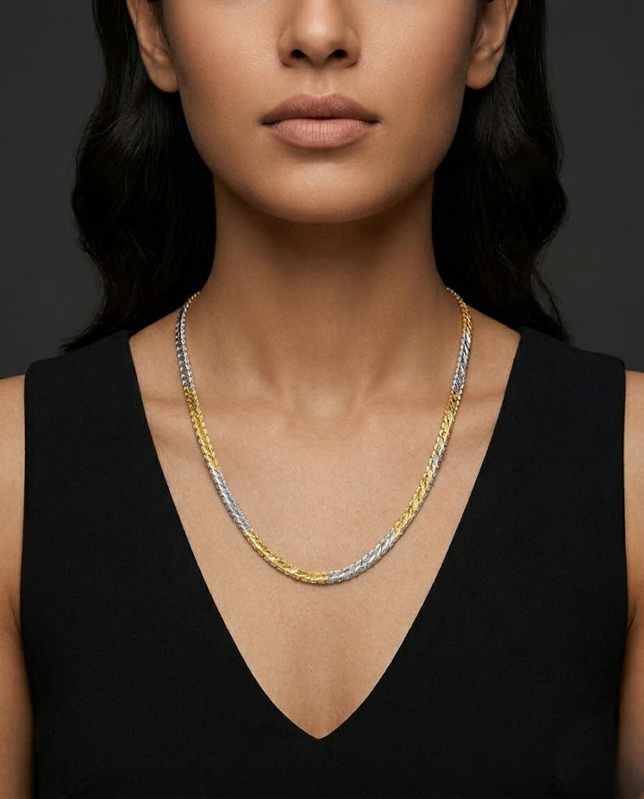 Woman wearing a three-strand necklace with gold, silver, and bronze links against a dark background