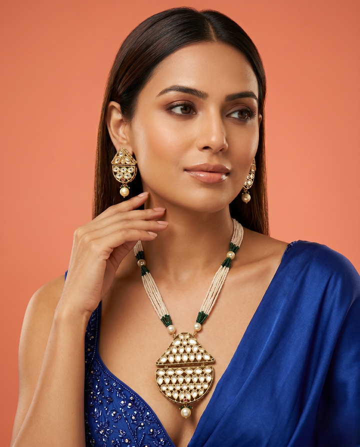 Woman wearing gold jewelry against a warm-toned background