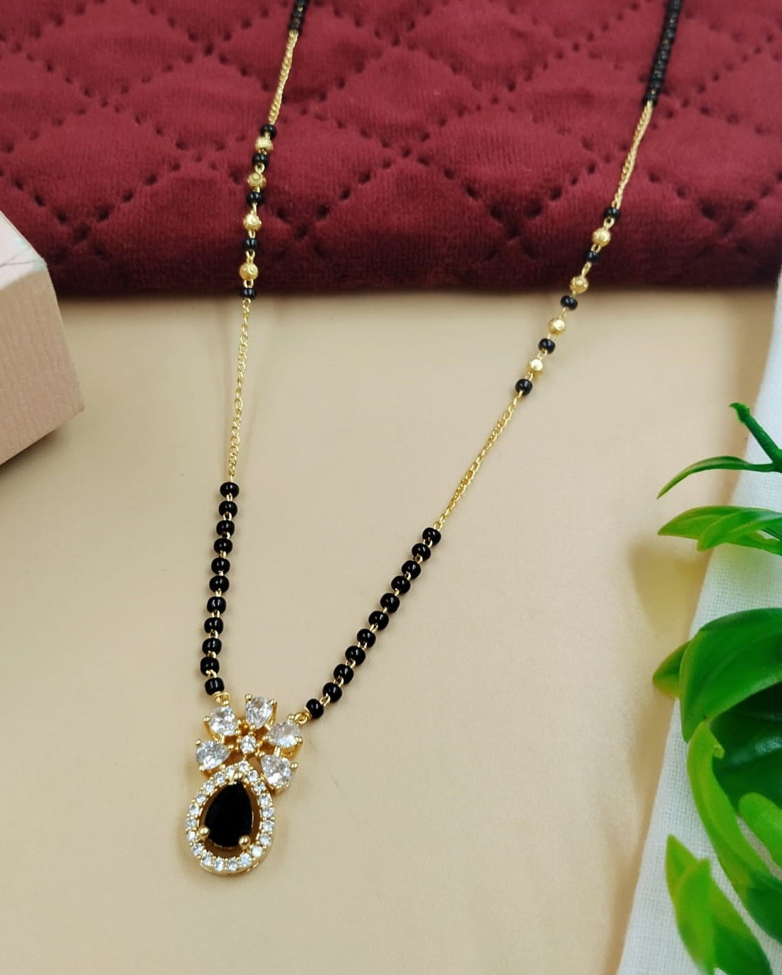 Elegant women’s mangalsutra designed with floral motif and black stone accents