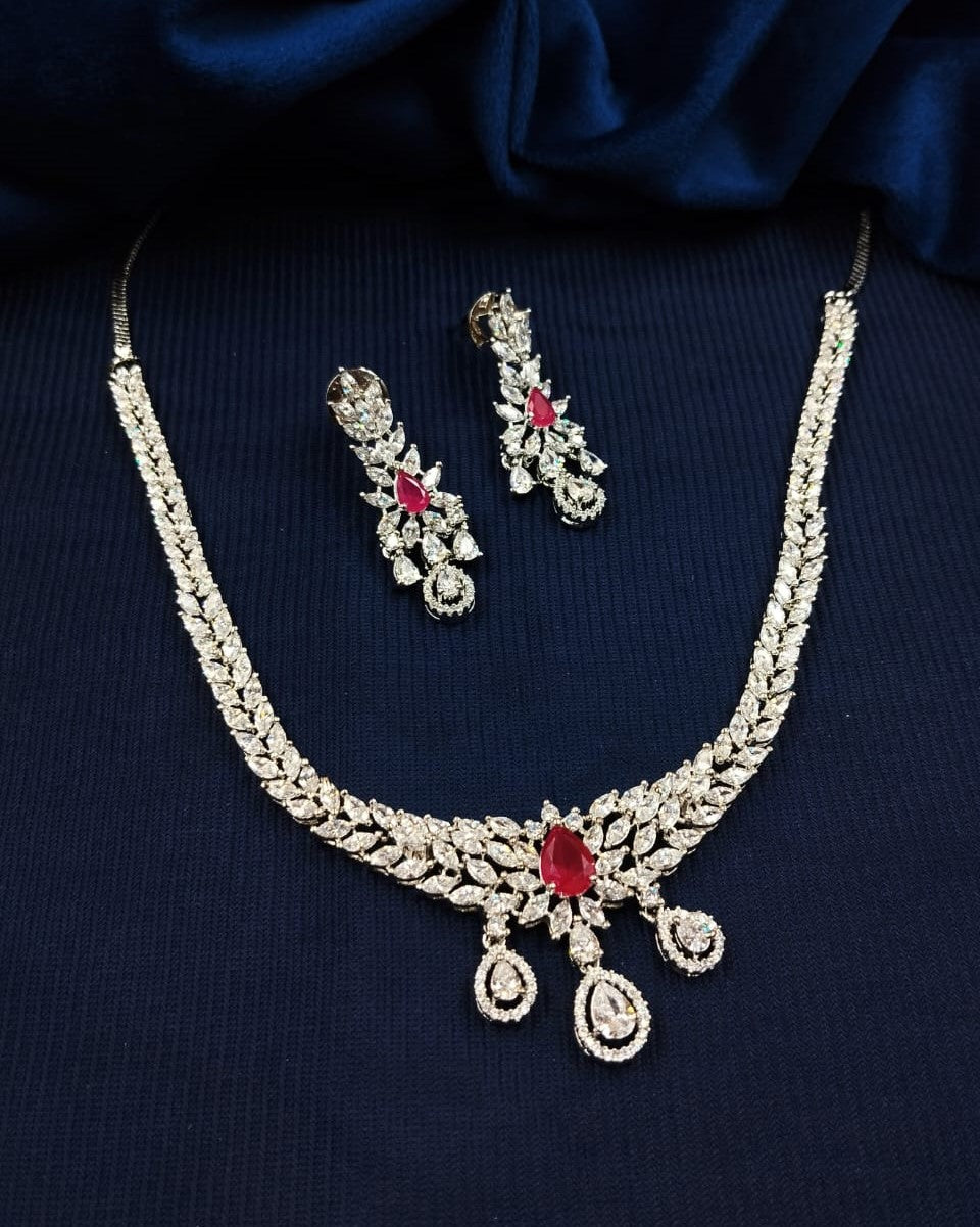 Jewelry set with necklace and earrings on a dark blue fabric background