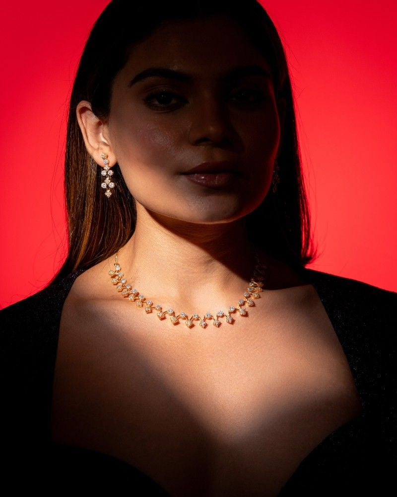 Woman wearing a necklace and earrings against a red background